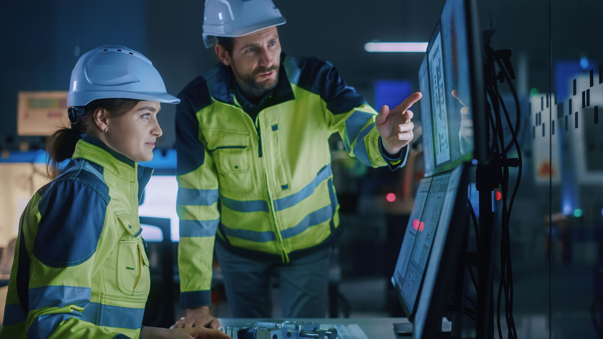 Twee ingenieurs bekijken onderhoudsdata in een controleruimte